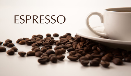 cup of black coffee and roasted coffe beans close-up with title espressoの写真素材