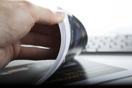 the hand through the pages of the magazine closeupの写真素材