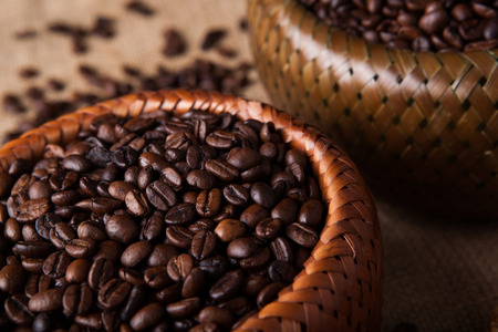 roasted coffee beans in a bamboo basket close upの写真素材