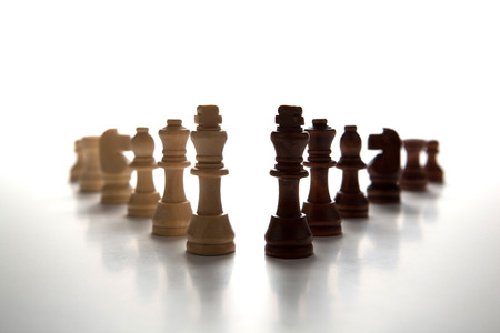 chess pieces lined up in a row on a gray close upの写真素材