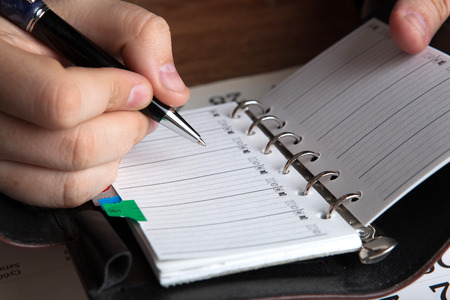 man running with diaries with pen close upの写真素材