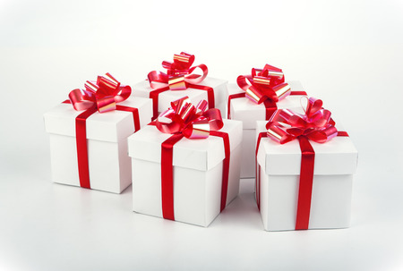 White gift boxes with red ribbons and bows on grayの写真素材