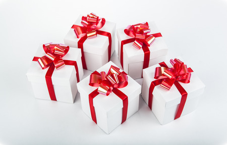White gift boxes with red ribbons and bows on grayの写真素材