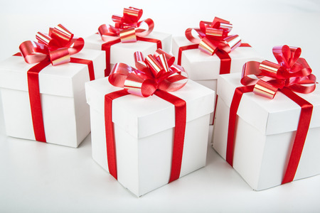 White gift boxes with red ribbons and bows on grayの写真素材