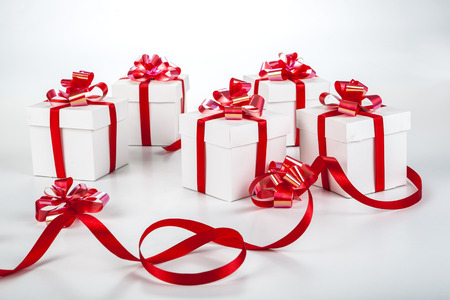 White gift boxes with red ribbons and bows on grayの写真素材