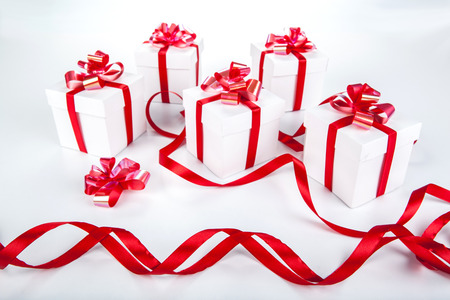 White gift boxes with red ribbons and bows on grayの写真素材