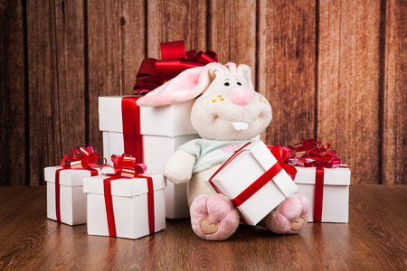white gift boxes and soft toy on a wood backgroundの写真素材