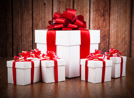 one large white gift box and white gift boxes on a wood backgroundの写真素材