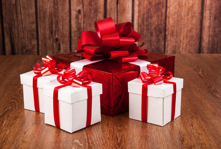 one red gift box white gift boxes on a wood backgroundの写真素材
