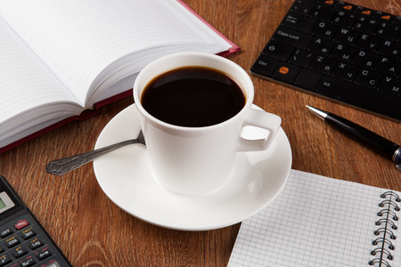 business still life with cup of black coffee on desktopの写真素材