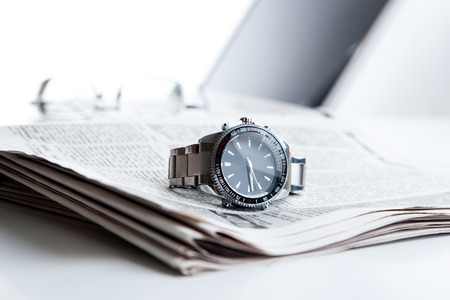 watch businessman on newspaper on him desktopの写真素材