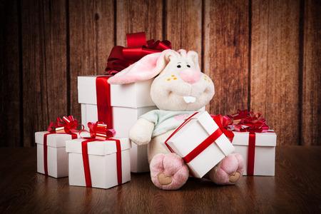 white gift boxes and soft toy on a wood backgroundの写真素材
