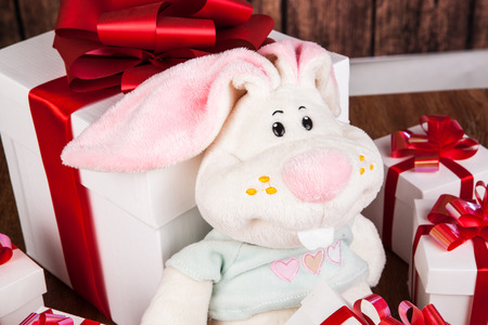 white gift boxes and soft toy on a wood backgroundの写真素材