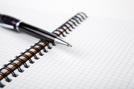 pen on a notebook into a cell close upの写真素材