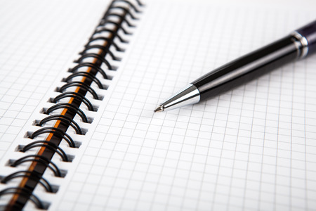 pen on a notebook into a cell close upの写真素材