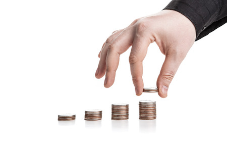 stack of coins and human hand on a white backgroundの写真素材
