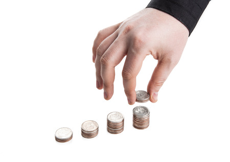 stack of coins and human hand on a white backgroundの写真素材