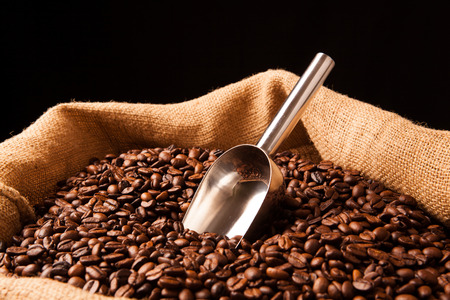 roasted coffee beans with scoop in bag close upの写真素材