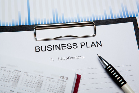 Document with title business plan and office suppliesの写真素材