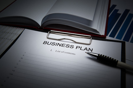 Document with title business plan and office suppliesの写真素材