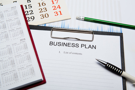 Document with title business plan and office suppliesの写真素材