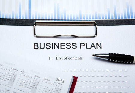 Document with title business plan and office suppliesの写真素材