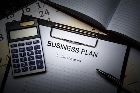 Document with title business plan and office suppliesの写真素材