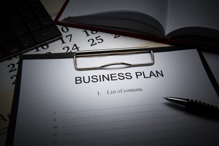 Document with title business plan and office suppliesの写真素材