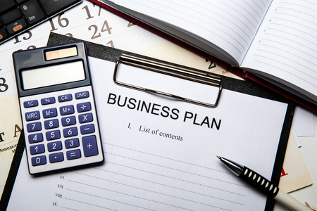 Document with title business plan and office suppliesの写真素材