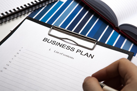 working hand in front of a desk and office suppliesの写真素材