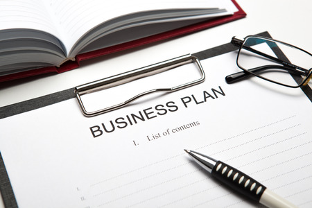 Document with title business plan and office suppliesの写真素材