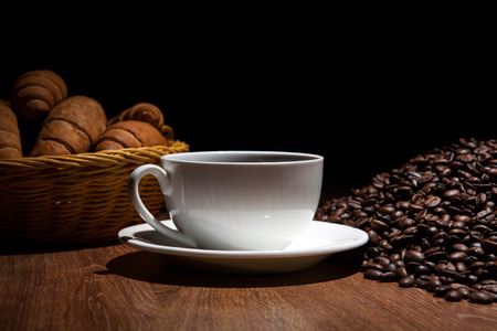 cup of coffee and roasted beans with croissantsの写真素材