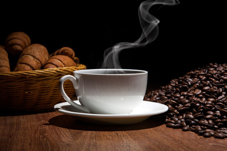 cup of coffee and roasted beans with croissantsの写真素材