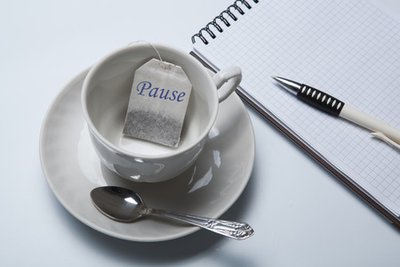 business still-life with with a cup of tea and tea bags and notepadの写真素材