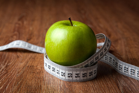 fresh green apple on a wooden table with measure close upの写真素材
