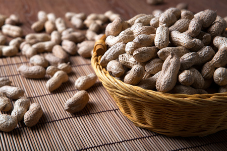 large grains of peanuts in the shell and basket close upの写真素材