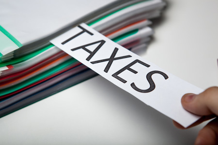 metaphor for the payment of taxes hand close upの写真素材