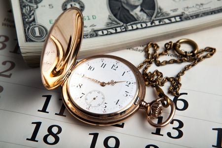 gold watch and dollar bills close upの写真素材
