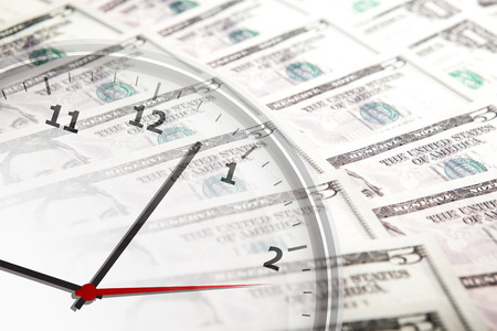clock on the background of banknotes dollars close up