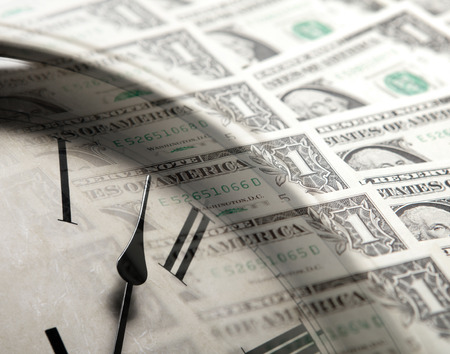 clock on the background of banknotes dollars close up