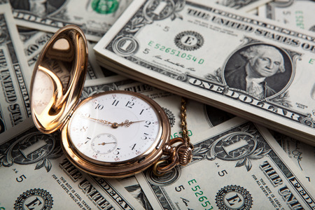 gold watch and dollar bills close upの写真素材