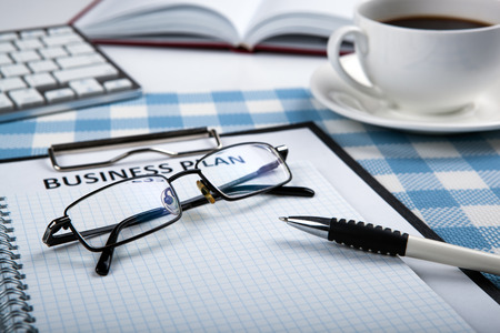 Document with title business plan and office supplies and glassesの写真素材