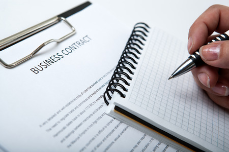 man holds a pen and signs the contract and diaryの写真素材