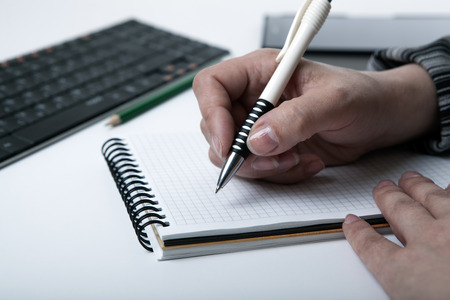 diary and human hand holding a pen close-upの写真素材