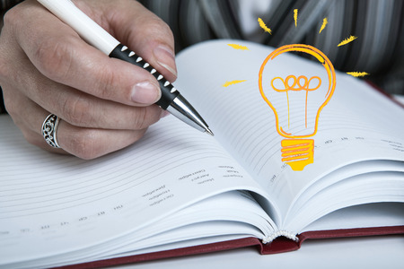 diary and human hand holding a pen close-upの写真素材