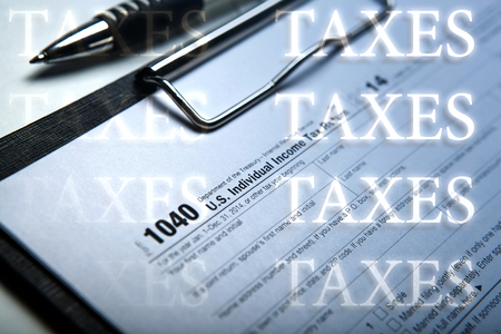 office work and filling in tax form with inscriptions taxes close upの写真素材