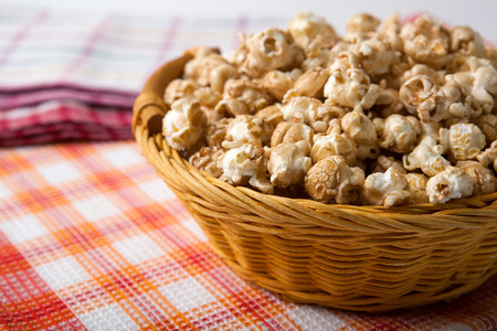 caramel popcorn in a basket on a napkin close upの写真素材