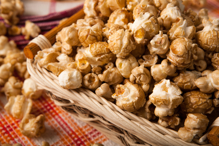 caramel popcorn in a basket on a napkin close upの写真素材
