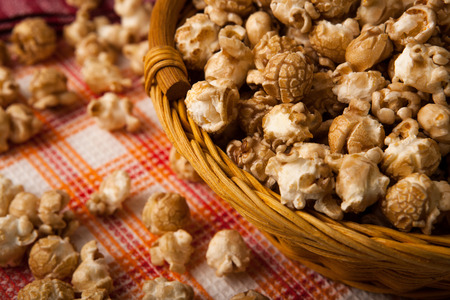 caramel popcorn in a basket on a napkin close upの写真素材