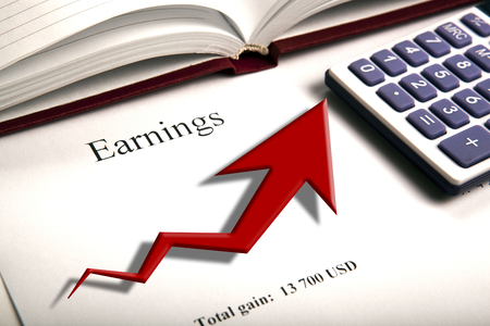 table with earnings with digits, calculator and diagram close upの写真素材